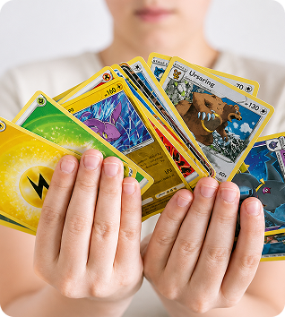 Hands holding a pile of various Pokémon cards